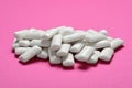 Tasty white chewing gums on pink background