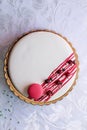 Tasty white homemade cake decorated by red berries and macaron