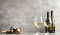 Tasty white wine in glasses and bottle on light grey background, space for text Royalty Free Stock Photo