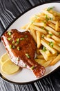 Tasty whole fried Sebastes fish served with fresh lemon and French fries close-up in a plate. vertical Royalty Free Stock Photo