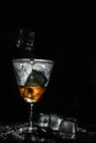 Tasty wine pouring in beautiful misted vintage glass with pieces of ice