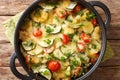 Tasty zucchini gratin with cheese and cherry tomatoes close-up in a pan. horizontal top view