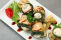 Tasty zucchini rolls with cheese and sauce on plate