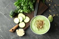 Tasty zucchini soup with pumpkin seeds in bowl on dark table