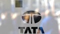 Tata Group logo on a glass against blurred crowd on the steet. Editorial 3D rendering