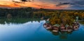 Tata, Hungary - Aerial panoramic view of a beautiful autumn sunset over wooden fishing cottages on a small island at Lake Derito Royalty Free Stock Photo