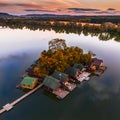 Tata, Hungary - Beautiful autumn sunset over wooden fishing cottages on a small island at Lake Derito Derito-to in October Royalty Free Stock Photo