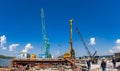 Cranes and pile-driving machines at the construction of a bridge over the Volga River.