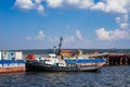 The tug is moored around the barge.