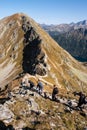 Tourists hiking on a trail on a mountain pass towards Miedziane Peak in Tatra Mountains during autumn. Royalty Free Stock Photo