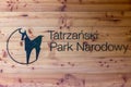 Tatra National Park Tatrzanski Park Narodowy black sign - logo and caption on a brown wooden background wall in Tatra Mountains