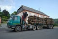 Tatra T815 heavy-duty truck operated by a logging company loaded with cut-off tree logs parked in a village