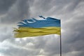 Tattered shabby Ukraine flag on gray cloudy