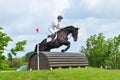 Tattersalls horse show in Ireland, black horse jumping over obstacle with male rider, jockey