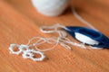 Tatting lace in the manufacturing process. Fragment of lace and shuttle on textile background close-up. Hobbies and leisure