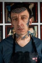 Tattoo artist in black leather apron in studio