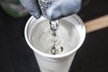 Tattoo artist cleaning the machine needles on water