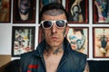 Tattoo artist in denim vest and sunglasses