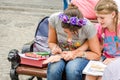 Tattoo artist doing temporary henna tattoo on the hand of the girl