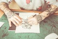 Tattoo artist drawing new flower illustration inside ink studio - Hipster tattoer at work - New fashion lifestyle artistic trends