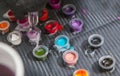 Tattoo artist mixing colors into small cup for ink