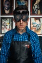 Tattoo artist in welder glasses in studio