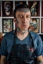 Tattoo master in black leather apron in studio