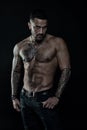 Tattoo model with six pack and ab. Bearded man with tattooed body. Man with bare torso in jeans. Athlete or