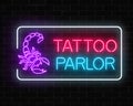 Tattoo parlor glowing neon signboard with scorpio emblem. Tattooing salon sign in rectangle frame. Royalty Free Stock Photo