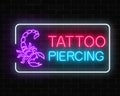 Tattoo and piercing parlor glowing neon signboard with scorpio emblem. Royalty Free Stock Photo