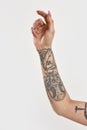 Tattoo and piercing. A tattooed hand of a white woman raised up a bit with fingers relaxed