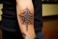 tattoo on wrist featuring a cowboy hat and sheriffs star Royalty Free Stock Photo