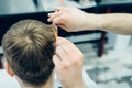 Tattooed Barber cuts the hair of the client with scissors. Close up. Attractive male is getting a modern haircut in Royalty Free Stock Photo