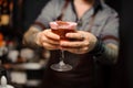 Tattooed barman hands holding a cocktail glass Royalty Free Stock Photo