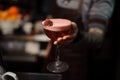 Tattooed bartender hands holding a cocktail glass Royalty Free Stock Photo