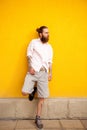 Tattooed bearded attractive man on yellow wall