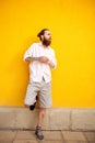 Tattooed bearded attractive man on yellow wall