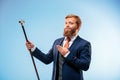 Tattooed bearded man in a suit holding cane. Royalty Free Stock Photo