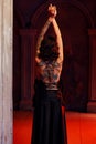 Tattooed beautiful woman in old spooky interior. Rear view. Goth theme Royalty Free Stock Photo