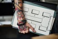 Tattooed hand holding a clipboard