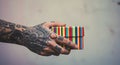 Tattooed hand holding a striped gift box Royalty Free Stock Photo