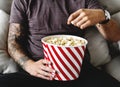 A tattooed man having popcorn