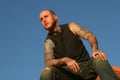 Tattooed man sitting on top of red rocks Royalty Free Stock Photo