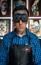 Tattooed man in welder glasses and shirt