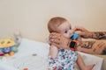 Tattooed mom playing with her baby in a hospital office. Royalty Free Stock Photo