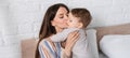 tattooed mother kissing baby boy in Royalty Free Stock Photo