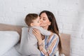 tattooed mother kissing baby boy in Royalty Free Stock Photo