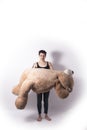 Tattooed natual looking woman playing with giant teddy bear