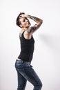 Tattooed natual looking woman with short black hair and face expression on bright background