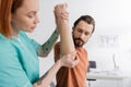 tattooed physiotherapist flexing arm of bearded Royalty Free Stock Photo